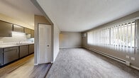 Located at 2704 Westmar Ct in Toledo, Ohio, this single-floor, 2-bedroom, 1-bathroom unit offers a practical and functional layout. The living room is a comfortable, carpeted space bathed in natural light through large windows dressed with vertical blinds. A wall-mounted air conditioning unit and baseboard heating ensure year-round comfort. The galley-style kitchen features dark cabinetry with ample overhead storage, a double-basin sink, light countertops, and a white electric range, all set atop wood-look flooring. The spacious primary bedroom is generously sized and includes two louvered bi-fold closet doors, providing abundant storage. The second bedroom also features plush carpeting, a window with natural light, and baseboard heating. Both bedrooms are finished in neutral, warm-toned paint. The full bathroom includes a tub/shower combination with a clean, white surround. Throughout the unit, four closets offer exceptional storage capacity. The space maintains a neutral, understated aesthetic with textured ceilings, clean white trim, and a consistent warm-gray color palette, creating a calm and move-in-ready environment.