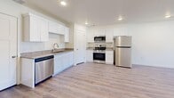 This contemporary residence at 900 Century Dr, Ogden, UT, offers 1330 square feet of thoughtfully designed living space across two floors. The home features three bedrooms, including a generous 240 square foot primary bedroom, and two full bathrooms. The main living area showcases an open-concept design, combining the kitchen and living room for a spacious feel. The kitchen boasts modern white cabinetry, stainless steel appliances, and granite countertops, creating a stylish and functional cooking space. Throughout the home, you'll find a mix of durable laminate flooring and plush carpeting, enhancing comfort and easy maintenance. Large windows in the living areas and bedrooms allow ample natural light, while ceiling fans and recessed lighting provide additional illumination and airflow. The bathrooms are equipped with contemporary fixtures, including a combination tub-shower unit. For organization, the house includes three closets and a separate laundry area. With its clean lines, neutral color palette, and updated features, this home offers a fresh and inviting living environment.