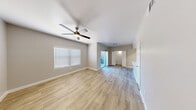 Located at 9620 W Russell Rd in Las Vegas, NV, this well-appointed 3-bedroom, 2-bathroom single-story home offers a functional and comfortable layout. The open living area features light wood-look flooring, neutral gray walls, a ceiling fan, and a window fitted with blinds that allows natural light to fill the space. A sliding glass door connects the living area to the exterior, enhancing the sense of openness. The kitchen is a standout feature, showcasing a central island with a built-in sink, stainless steel appliances including a refrigerator, microwave, and range, white cabinetry, and a tiled backsplash — all complemented by the continuous wood-look flooring. The primary bedroom is generously sized and includes a ceiling fan, while the additional bedrooms feature plush carpeting and windows with blinds. Three closets provide ample storage, including a walk-in closet with wire shelving. The bathrooms are clean and modern, with one featuring a dual-sink vanity, wood-look tile flooring, and a tiled tub-shower combo. A dedicated laundry area with an in-unit washer adds everyday convenience. The home's cohesive neutral palette and practical layout make it a well-rounded living space.