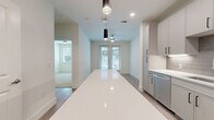 This 580 square foot apartment in Lewisville, TX offers a harmonious blend of style and functionality. The space is intelligently designed to maximize every inch of its single-floor layout. The centerpiece is a generously sized 220 square foot bedroom, providing ample space for rest and relaxation. The modern kitchen is a highlight, featuring sleek white cabinetry, stainless steel appliances, and a practical island that doubles as a breakfast bar. Light wood-look flooring throughout creates a sense of continuity and warmth. Large windows in the bedroom allow natural light to flood the space, while offering views of the surrounding greenery. The bathroom, though not explicitly mentioned, likely continues the contemporary aesthetic. Recessed lighting and pendant fixtures add to the overall modern ambiance. With its efficient layout and updated finishes, this apartment presents an ideal living space for those seeking comfort and style in a compact urban setting.