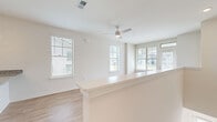 Located at 22360 Bushel Dr in Fairhope, Alabama, this thoughtfully designed one-bedroom, two-bathroom home offers a clean, modern aesthetic with an efficient and well-organized single-floor layout. The open-concept living and kitchen area serves as the heart of the home, where light wood-look flooring, crisp white walls, and multiple windows create a bright and airy atmosphere. A ceiling fan adds to the comfort of the living space, which flows seamlessly toward a glass-paneled exterior door that invites natural light from multiple directions.

The kitchen is a standout feature, equipped with white shaker-style cabinetry, granite countertops, a white subway tile backsplash, and stainless steel appliances including a refrigerator and dishwasher. A central island with a built-in sink and pendant lighting above adds both functionality and style.

The bedroom is a comfortable, sun-filled retreat with a ceiling fan, large window, and light wood-look flooring. It connects to a spacious walk-in closet outfitted with wire shelving and hanging rods for ample storage. Both bathrooms are finished with granite-topped white vanities, and one features a full soaking tub with shower. The home's consistent finishes and clean design create a cohesive, move-in-ready living environment.