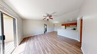 This single-floor, 3-bedroom, 2-bathroom residence offers a thoughtfully designed layout that maximizes comfort and functionality. The open-concept living room and kitchen area serves as the heart of the home, featuring warm wood-look luxury vinyl plank flooring, vaulted ceilings, and a ceiling fan that enhances airflow and light. A sliding glass door connects the living area directly to a private balcony, bringing in abundant natural light and outdoor views of surrounding greenery.

The kitchen is equipped with warm-toned wood cabinetry, white appliances including a refrigerator and range, a double sink, and track lighting overhead. A breakfast bar separates the kitchen from the living area, creating a practical and social layout.

The three bedrooms offer a mix of flooring options — two feature plush carpeting with ceiling fans and windows framing outdoor views, while the third is finished with matching vinyl plank flooring and overhead lighting. The primary bedroom is a well-proportioned retreat with its own dedicated space.

Both bathrooms are finished consistently, featuring wood-tone vanity cabinetry, granite-style countertops, full shower-tub combinations, and wood-look flooring. Two hallways connect the rooms efficiently, and a dedicated closet provides additional storage. Neutral gray walls throughout create a clean, cohesive aesthetic.