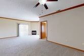 Located at Cedar Plaza in Omaha, Nebraska, this well-appointed 2-bedroom, 3-bathroom single-floor home offers a comfortable and functional layout. A welcoming hallway with hardwood-style flooring transitions into the open-concept kitchen and living area. The kitchen features warm oak cabinetry, ample counter space, and a practical pass-through design. The spacious living room is a standout, boasting a corner fireplace framed by two large sliding glass doors that flood the room with natural light and provide access to an outdoor balcony area. A ceiling fan adds to the room's comfort. Each bedroom is carpeted and equipped with a ceiling fan, with one bedroom featuring a large window overlooking the outdoors and an open closet with built-in rod storage. The primary bedroom is generously sized and includes dedicated closet space. The primary bathroom offers dual sinks with a wide vanity, hardwood-style flooring, and a full tub-shower combination. The home also includes a dedicated laundry room with hookups, cabinetry, and hard-surface flooring. Crown molding details and consistent warm-toned trim throughout tie the space together, creating a cohesive and inviting ambiance.