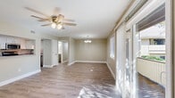 Located at 2 Hollandale Ln in Clifton Park, NY, this well-appointed 2-bedroom, 2-bathroom single-floor home offers a thoughtfully designed layout with a clean, modern aesthetic throughout. Light-toned luxury vinyl plank flooring runs seamlessly through the main living areas and bedrooms, lending a cohesive and contemporary feel.

The open-concept living room is bright and airy, featuring a ceiling fan with light fixture, a sliding glass door leading to an outdoor area, and an additional window that together flood the space with natural light. A chandelier-lit dining area transitions smoothly into the kitchen, which is equipped with white cabinetry, stainless steel appliances including a refrigerator, range, microwave, and dishwasher, complemented by a tile backsplash and a pass-through counter connecting to the living area.

The generously sized primary bedroom includes a ceiling fan, a sliding closet, and a window with outdoor views. The second bedroom also features a ceiling fan and its own window, offering a comfortable and private retreat. Both bathrooms are finished in a neutral palette with clean, functional fixtures. Throughout the home, six closets provide exceptional storage, while two hallways ensure a practical and well-connected floor plan. Neutral taupe walls and white trim complete the polished interior.