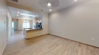 This single-floor home offers a clean, modern aesthetic defined by consistent wood-look tile flooring that flows seamlessly throughout every room, creating a cohesive and low-maintenance living environment. The open-concept kitchen is a standout feature, outfitted with light maple cabinetry, dark slate-toned countertops, stainless steel appliances including a gas range, microwave, and refrigerator, and a decorative tile backsplash. A skylight overhead floods the kitchen with natural light, while a central island with additional counter space enhances functionality. The kitchen transitions naturally into the dining area, which is accented by a rustic chandelier, and the adjoining living area, which features a ceiling fan and recessed lighting. The bedrooms are generously proportioned, each with natural light from windows fitted with blinds, ceiling fans, and neutral wall tones that lend a calm, airy feel. One bedroom includes a double-door closet for ample storage. The bathroom is thoughtfully designed with a granite-topped vanity, light maple cabinetry, a large framed mirror, and a tub-shower combination surrounded by floor-to-ceiling wood-grain tile, complemented by a recessed niche and a small privacy window for natural ventilation.