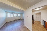 Located in Redmond, WA, this single-floor 1-bedroom, 1-bathroom unit offers a functional and well-organized layout. The living room is bright and open, featuring light wood-look flooring, a textured ceiling, and a bank of windows fitted with blinds that invite generous natural light. A baseboard heating system runs along the exterior wall, ensuring comfort year-round. The space flows naturally into a dedicated dining area and connects to the kitchen via an open passage. The galley-style kitchen is well-appointed with warm wood cabinetry, white quartz countertops, a stainless steel refrigerator, electric range, and dishwasher — providing excellent functionality in a compact footprint. The bedroom is a comfortable, quiet retreat with its own window, baseboard heater, and a large sliding-door closet offering substantial storage. Two additional closets throughout the unit further enhance storage capacity. The bathroom features a full tub and shower combination with chrome fixtures and clean white surround. Wood-look flooring carries throughout the main living areas, tying the space together with a cohesive, modern aesthetic. A hallway connects the rooms efficiently, completing this smartly designed Redmond residence.