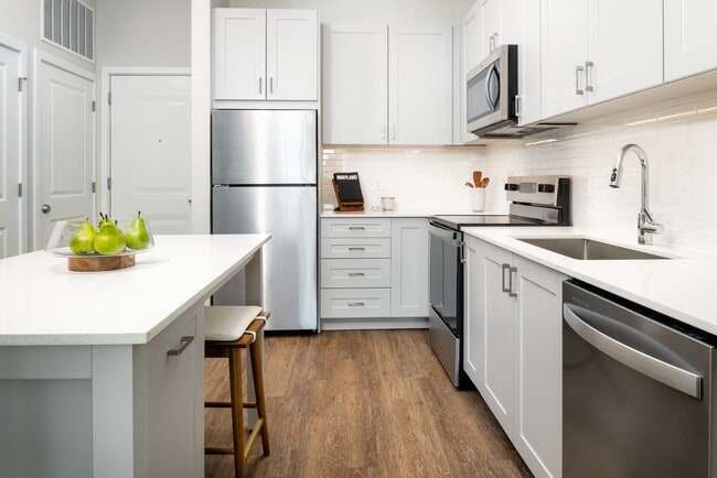 Nueva Fase Oeste - Paquete de acabados III Cocina con electrodomésticos de acero inoxidable, encimeras de cuarzo blanco, gabinetes grises y pisos de superficie dura - Avalon Hunt Valley and Hunt Valley West