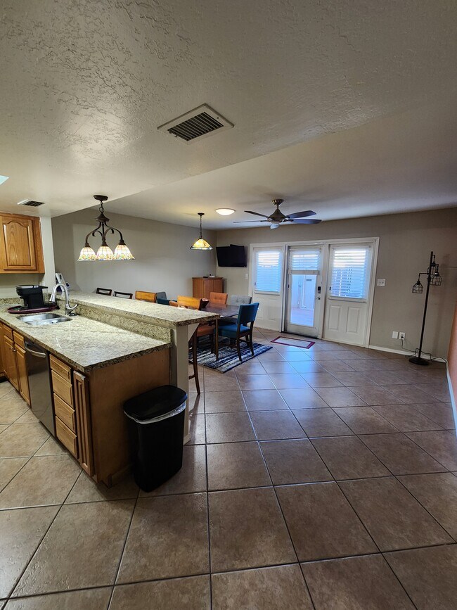 Comedor acogedor con barra de desayuno. Con acceso a un patio cubierto. - 5050 N 81st St