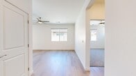 This single-story home on Calloway Drive in Bakersfield, California offers a thoughtfully arranged floor plan with two bedrooms and three bathrooms. The interior is finished with a clean, modern aesthetic characterized by crisp white walls, light wood-style luxury vinyl flooring in the main living areas, and plush carpet in the bedrooms.

The combined kitchen and living room forms the heart of the home. The kitchen is equipped with shaker-style white cabinetry, white quartz countertops, a subway tile backsplash, stainless steel appliances, and a peninsula that provides additional prep and seating space. A sliding glass door leads directly to the private outdoor area, which features a concrete patio and a small patch of artificial turf surrounded by gravel landscaping.

The living room is bright and open, receiving natural light through multiple windows and featuring ceiling fans for comfort. The primary bedroom is a comfortable size with hardwood-style flooring, a ceiling fan, and direct access to a dedicated bathroom with a glass-enclosed shower and a walk-in closet fitted with built-in shelving and hanging rods. The second bedroom offers carpet flooring, a ceiling fan, and a window with exterior views. Additional bathrooms are finished with wood-style flooring and natural light from windows, maintaining the home's consistent, contemporary style throughout.