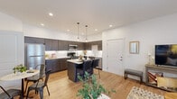 This well-designed 2-bedroom, 2-bathroom single-floor residence offers a thoughtfully laid-out open-concept floor plan that maximizes functionality. The kitchen serves as a central highlight, featuring dark espresso cabinetry extending to the ceiling, light quartz countertops, a white subway tile backsplash, and a full suite of stainless steel appliances. A center island with bar seating provides additional workspace and casual dining, while pendant lighting adds a modern touch overhead.

The kitchen flows seamlessly into the combined living and dining area, where light hardwood flooring runs throughout, creating visual continuity. The living room benefits from multiple windows allowing ample natural light, a sliding glass door, and a wall-mounted mini-split unit for climate control.

Both bedrooms are comfortably sized, with the primary bedroom featuring a dedicated closet and ceiling fan. The second bedroom includes a large window with exterior views. Each bathroom is finished with wide-format vanity mirrors, wood-toned cabinetry, light quartz countertops, and hardwood-style flooring. One bathroom includes a full tub-shower combination. A dedicated closet adds practical storage to round out this efficiently designed residence.