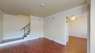 Located at 277 Monroe St in Oswego, IL, this two-story home offers a practical and comfortable layout across two floors. Rich hardwood-style flooring flows consistently throughout the entire home, creating a warm and cohesive aesthetic in every room.

The main floor welcomes you through a front entry door with an oval decorative window, opening into a bright living room adorned with crown molding and a staircase featuring a classic black metal railing. The adjacent kitchen and dining area is well-equipped with dark wood cabinetry, granite-look countertops, a double sink, and a gas range, providing ample storage and workspace. A combined dining and kitchen space adds versatility to the main level.

Upstairs, two bedrooms offer comfortable retreats, each featuring ceiling fans, natural light from windows with blinds, and generous closet space with bifold doors. The spacious primary bedroom provides a relaxing environment with ample room for furnishings. A hallway connects the upper-level rooms, and a full bathroom with a tub-shower combination completes the second floor.

Throughout the home, six closets provide abundant storage, and the neutral warm-beige wall palette gives each space a clean, move-in-ready appeal. The home's efficient two-floor design makes excellent use of its overall footprint.