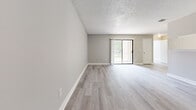 This 2-bedroom, 2-bathroom single-floor residence at 4901 Bottlebrush Ln in Orlando, Florida offers a clean, modern aesthetic throughout. Light-toned luxury vinyl plank flooring runs consistently across all rooms, complemented by neutral gray walls and crisp white baseboards that create a bright, cohesive feel.

The open living room is a comfortable, well-proportioned space featuring a textured popcorn ceiling and a sliding glass door that invites natural light and provides direct access to the outdoors. The galley-style kitchen is efficiently laid out with white cabinetry, light granite-style countertops, a stainless sink, and white appliances including a range and refrigerator.

The primary bedroom is a generously sized retreat with a dedicated closet, while the second bedroom features a large window with blinds that frames a green outdoor view, filling the room with natural light. Both bathrooms are finished consistently, each offering a tub/shower combination, white vanity cabinetry with granite-style countertops, and matching flooring. A dedicated entrance and additional closet round out the layout. The overall ambiance is clean, neutral, and move-in ready, offering a practical and comfortable living environment in Orlando.
