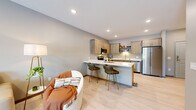Located at 3509 S Broadway St in Alexandria, MN, this well-designed 3-bedroom, 1-bathroom residence offers a thoughtfully laid-out single-floor plan. The open-concept kitchen and living area form the heart of the home, featuring light wood cabinetry, stainless steel appliances including a refrigerator, range, microwave, and dishwasher, and a peninsula with seating — ideal for both cooking and casual dining. Light luxury vinyl plank flooring runs throughout the main living areas, enhancing the bright, airy atmosphere created by recessed lighting and neutral gray-toned walls. The living room provides a comfortable retreat with a large window that invites natural light and outdoor views. The three bedrooms are finished with plush carpeting and feature windows that bring in additional natural light, with the primary bedroom offering a generous footprint. The full bathroom is cleanly appointed with a soaking tub and shower combo, a wood-toned vanity with ample storage, and brushed nickel fixtures. A dedicated laundry room with overhead cabinetry and full-size washer and dryer hookups adds everyday convenience. The overall design aesthetic is modern and cohesive, with consistent warm neutral tones throughout.
