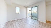 Located in the vibrant West Lake neighborhood of Los Angeles, this efficient one-bedroom, one-bathroom unit offers a thoughtfully designed modern interior across a single floor. The open kitchen and living area serves as the heart of the unit, featuring sleek flat-front cabinetry in white and warm wood tones, stainless steel appliances including an electric range, built-in microwave, and dishwasher, complemented by clean white quartz countertops and light wood-style flooring throughout. A stacked washer and dryer unit is conveniently integrated into the living space. Large windows in the main living area flood the space with natural light while framing views of the surrounding cityscape and palm-lined streets. The bedroom is a calm, carpeted retreat featuring a generous corner window that captures sweeping views of the Los Angeles skyline and neighboring rooftops, adding an elevated feel to the cozy room. A closet provides practical storage. The bathroom is finished in a clean, contemporary style with large-format tile flooring, a wood-toned vanity with white countertop, a wide mirror, and a tub-shower combination. The overall aesthetic is bright, minimalist, and move-in ready, ideal for those seeking a modern urban lifestyle in Los Angeles.