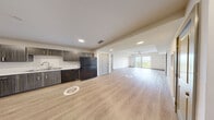 Located at Coco Plum Drive in Marathon, Florida, this two-bedroom, two-bathroom unit offers a clean, contemporary design throughout its single-floor layout. Light wood-style flooring runs consistently across all rooms, lending a cohesive and airy feel to the space.

The open living area is a standout feature, anchored by a sliding glass door that opens to a private balcony overlooking lush treetops and a scenic waterway — a classic Florida Keys backdrop. A ceiling fan overhead and abundant natural light enhance the comfort of this central gathering space.

The kitchen is well-appointed with dark wood-grain cabinetry, light countertops, a stainless double-basin sink, and black appliances including a refrigerator, range with over-the-range microwave, and dishwasher. Recessed lighting adds a polished finish.

Both bedrooms feature light-toned walls, wood-style flooring, and ceiling fans. The primary bedroom includes a window with waterway views. Each bathroom is fitted with a tub-shower combination, light wood flooring, and brushed nickel fixtures and grab bars. One bathroom includes a dark wood vanity with ample drawer storage.