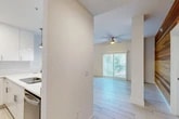 Located in Jacksonville Beach, FL, this well-appointed single-floor residence offers 2 bedrooms, 2 bathrooms, a den, and a dedicated laundry area across a thoughtfully designed layout. The open-concept living, dining, and kitchen area serves as the heart of the home, highlighted by light-toned tile flooring and a bold horizontal wood-plank accent wall that adds warmth and texture to the space. Sliding glass doors and plantation-shuttered windows flood the living area with natural light, while a ceiling fan adds to the coastal ambiance.

The kitchen features sleek white cabinetry, a white subway tile backsplash, quartz countertops, stainless steel appliances including a refrigerator and dishwasher, and pendant lighting over the extended breakfast bar — a clean, modern aesthetic throughout.

Both bedrooms are carpeted and feature ceiling fans, with ample closet access. The primary bedroom connects directly to its own bathroom, which showcases large-format tile flooring, a white vanity with quartz countertop, brushed gold fixtures, and a glass-enclosed walk-in shower with floor-to-ceiling tile surround. The second bathroom mirrors this refined design. With four closets and a dedicated den, this residence provides generous storage and flexible living options.