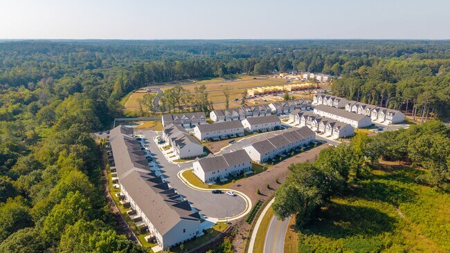 Vista aérea comunitaria que muestra casas, calles y espacios verdes desde arriba. - Carlton Crossing