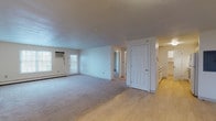 Located at 195 Eastern Ave in Manchester, New Hampshire, this single-floor unit offers a practical and well-organized layout across multiple rooms. The open living area is generously sized, featuring neutral carpet flooring and a wall-mounted air conditioning unit alongside windows that allow natural light to fill the space. A secondary living or flex room provides additional space with carpet flooring, a large window with blinds, and baseboard heating — a consistent feature throughout the unit.

The galley-style kitchen is efficiently designed with white cabinetry trimmed in wood accents lining both walls, providing ample storage. Light hardwood-style flooring, a stainless single-basin sink, a range with oven, dishwasher, and a full-size refrigerator complete the functional kitchen space.

Two full bathrooms are present in the unit, each featuring a tub-shower combination, toilet, vanity, and light hardwood-style flooring. One bathroom includes a medicine cabinet with additional shelving for storage.

The bedrooms are carpeted, bright, and well-proportioned, each with windows and baseboard heating. Neutral wall tones and clean finishes are consistent throughout, giving the unit a simple, move-in-ready aesthetic. Closet and storage access is visible in multiple areas of the floor plan.