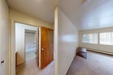 Located at 323 Packard St in Ann Arbor, Michigan, this one-bedroom, one-bathroom unit offers a practical and efficient single-floor layout. The combined living and dining area serves as the heart of the unit, featuring wall-to-wall carpeting, a wall-mounted air conditioning unit, and a baseboard heating system. Two windows along the exterior wall allow natural light to fill the space, fitted with vertical blinds for privacy. The kitchen is semi-open to the living area and is equipped with white cabinetry, including glass-front upper cabinets, a built-in countertop bar, and tile flooring, providing a functional workspace. A hallway connects the main living spaces to the private areas of the unit. The bedroom is generously sized with soft carpeting and features a full-width built-in closet along one wall, offering ample storage. An additional closet is accessible from the hallway. The bathroom includes a full tub and shower combination with classic white square tile surround. Throughout the unit, neutral wall tones and light-colored finishes create a clean, understated aesthetic well-suited for comfortable everyday living.