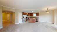 Located at Emerson Plaza in Altamonte Springs, Florida, this 2-bedroom, 2-bathroom residence offers a thoughtfully designed single-floor layout. The kitchen is a standout feature, showcasing rich cherry wood cabinetry, granite countertops, stainless steel appliances, tile flooring, and a central island that provides additional prep and seating space. It opens seamlessly toward the living room, which is carpeted and bathed in natural light through dual sliding glass doors that lead to a curved private balcony. The balcony, finished with tile flooring and a glass railing, overlooks lush greenery and a tranquil waterway, creating a serene outdoor retreat. The primary bedroom is generously sized, carpeted, and features crown molding, while the second bedroom also offers carpet, crown molding, and a window with natural light. Both bathrooms are finished with tile flooring and warm wood vanities; one includes a tiled tub-and-shower combination. Additional spaces include a hallway, a utility room, and a closet, contributing to practical day-to-day functionality. Throughout the residence, warm neutral tones and crown molding detailing lend a cohesive, polished aesthetic.