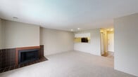 Located at 3030 Pebble Point Dr in Indianapolis, IN, this two-bedroom, two-bathroom residence offers a well-organized single-floor layout designed for comfortable everyday living. The open living room is a standout space, featuring soft carpeting, recessed lighting, and a tile-surround wood-burning fireplace that serves as a focal point. A pass-through counter connects the living area to the kitchen, enhancing the open feel while maintaining a defined cooking space. The kitchen is efficiently designed with light-colored cabinetry, ample counter space, a double basin sink, and black appliances including an electric range and refrigerator, all set on durable wood-look flooring. Both bedrooms are carpeted and neutral in tone, offering a calm and restful atmosphere. The primary bedroom benefits from a large window with outdoor views and features two closets, including a walk-in, providing generous storage. Each bathroom is equipped with a full tub and shower combination, maintaining a clean, functional design. Additional closet space throughout the unit adds to its practicality. The overall aesthetic is understated and move-in ready, with a consistent neutral color palette that lends itself well to a variety of furnishing styles.
