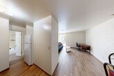 Located at 121 E Hoover in Ann Arbor, MI, this one-bedroom, one-bathroom unit offers a practical and efficient layout across a single floor. Wood-look plank flooring runs throughout the space, providing a cohesive and easy-to-maintain surface underfoot.

The open living and dining area serves as the heart of the unit, featuring painted concrete block walls that lend an understated, utilitarian character. A large window floods the space with natural light and offers views of the surrounding neighborhood. A ceiling fan overhead provides air circulation. This area comfortably accommodates both a seating arrangement and a dining table, making it versatile for everyday living.

The kitchen is positioned adjacent to the living area, separated by a partial wall. It includes a full-size refrigerator and essential appliances, offering a functional cooking space. Three closets throughout the unit provide generous storage options relative to the overall footprint.

The bedroom is a well-proportioned room with a window that brings in natural light and greenery views from outside, continuing the wood-look flooring found throughout.

The bathroom features a full bathtub and shower combination with classic cream-toned tile surround, keeping the space clean and straightforward. Overall, this unit delivers a functional and no-frills living environment well-suited for individuals seeking a practical home in Ann Arbor.