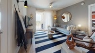 This single-floor residence offers a thoughtfully designed layout that balances modern aesthetics with everyday comfort. The open kitchen is a standout feature, outfitted with warm wood cabinetry, quartz countertops, stainless steel appliances including a range, microwave, and French door refrigerator, and a decorative mosaic tile backsplash. Light wood-style flooring grounds the space and flows seamlessly through the main living areas.

The living room is bright and inviting, featuring a sliding glass door that opens to a private balcony with open views, allowing natural light to fill the room. The space accommodates a comfortable sectional sofa and entertainment setup, creating an ideal setting for relaxing or entertaining.

Multiple bedrooms provide versatile living arrangements. One bedroom showcases a rich burgundy accent wall paired with framed artwork and a spacious desk area near the window. Another features a serene blue accent wall, gallery-style wall art, and direct balcony access with generous natural light. Additional bedrooms offer plush carpeting, ample storage, and refined décor.

The bathrooms are elegantly finished, including one with a walk-in glass-enclosed shower featuring large-format tile walls, mosaic tile flooring, and built-in open shelving. A second bathroom presents wood-tone vanity cabinetry, a wide mirror, and clean, modern fixtures. The overall ambiance is contemporary, cohesive, and welcoming throughout.