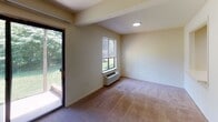 This single-floor, one-bedroom, one-bathroom unit in Highland Park, NJ offers a comfortable and practical layout surrounded by nature. The living area is spacious and carpeted, bathed in natural light through a large sliding glass door that opens to a private patio overlooking lush, mature trees — a hallmark of the Treetop setting. The room also features a wall unit for climate control and a standard window with blinds, ensuring year-round comfort. A second carpeted room, currently used as the bedroom, mirrors this design with its own window framing serene greenery views and a built-in PTAC wall unit. The kitchen is efficiently designed with warm wood cabinetry, a white countertop, a stainless steel sink, a white electric range, and tile flooring that adds durability to the workspace. Ample upper and lower cabinet storage makes the kitchen highly functional. The full bathroom is clean and well-appointed, featuring a tub-shower combination, a toilet, a vanity with storage, and mosaic tile flooring. Neutral tones throughout the unit create a calm and cohesive atmosphere, while the abundant greenery visible from multiple windows reinforces the natural, treetop ambiance this residence is named for.