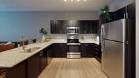 This single-floor residence offers a thoughtfully designed layout that balances modern style with everyday functionality. The kitchen serves as a standout feature, showcasing dark espresso cabinetry that extends to the ceiling for ample storage, light granite countertops, and a full suite of stainless steel appliances including a range, microwave, and refrigerator. Light-toned hardwood-style flooring runs throughout the kitchen and common areas, lending the space a bright, clean aesthetic that pairs well with the neutral gray wall tones.

The bedrooms are carpeted for comfort and feature large windows fitted with blinds that allow for generous natural light. The rooms offer a calm, restful atmosphere enhanced by warm-toned walls and functional layouts that accommodate full bedroom furniture sets with ease. The floor plan, visible in the dollhouse view, reveals a well-organized arrangement of interconnected rooms with clear sightlines between spaces.

The bathroom continues the design language of the kitchen, featuring dark cabinetry, a granite-topped vanity with an undermount sink, and built-in shelving for added storage. Together, the spaces reflect a cohesive, contemporary design aesthetic with quality finishes throughout.