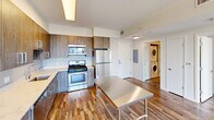 This contemporary 870 square foot apartment offers a harmonious blend of style and functionality. The open-concept design seamlessly integrates the living room and kitchen, creating a spacious feel enhanced by hardwood floors throughout. The kitchen boasts modern wood-grain cabinetry, stainless steel appliances, and a central island, perfect for meal preparation or casual dining.

Large windows in the bedrooms and living area flood the space with natural light and provide stunning city views, adding to the apartment's airy ambiance. The primary bedroom, an impressive 310 square feet, offers ample space for relaxation and storage.

The bathroom features clean lines with neutral-toned tiles and modern fixtures. A notable convenience is the in-unit laundry, tucked away yet easily accessible. The apartment's layout maximizes the use of space, with thoughtful design elements throughout.

Located in Stamford, CT, this single-story residence combines urban living with comfort. Its modern aesthetics, functional design, and city views make it an ideal home for those seeking a contemporary lifestyle in a vibrant setting.