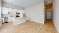 Located at 5808 Nall Ave in Mission, Kansas, this well-designed one-bedroom, one-bathroom unit offers a thoughtful, functional layout across a single floor. Light wood-look flooring runs throughout the space, complemented by neutral warm-gray walls and crisp white trim, creating a clean and cohesive aesthetic.

The open-concept living, dining, and kitchen area serves as the heart of the home. The kitchen is appointed with white shaker cabinetry, granite-look countertops, a breakfast bar peninsula, and stainless steel appliances including a refrigerator, range, and microwave. The adjoining living and dining areas benefit from ample natural light streaming through window blinds and a glass exterior door.

A hallway connects the main living area to the private bedroom, which offers a comfortable and quiet retreat with a dedicated closet for storage. The full bathroom features a white vanity with granite-look countertops, a tub-shower combo, and matching brushed nickel fixtures throughout.

A dedicated laundry room houses a full-size washer and dryer with wire shelving above, adding significant everyday convenience. The utility room includes an electrical panel, providing practical accessibility. The entrance corridor leads seamlessly into the main living space, maintaining an organized and efficient flow throughout the home.