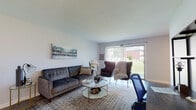 This single-floor residence offers a thoughtfully arranged layout that balances comfort and functionality across its key living spaces. The living room serves as the heart of the unit, featuring wood-style flooring, neutral walls, and a large sliding glass door that floods the space with natural light and provides views of a green outdoor area. A dedicated workspace with a shelving unit is seamlessly incorporated into the living area, adding versatility to the room.

The kitchen is well-equipped with white shaker-style cabinetry, granite countertops, a tile backsplash, and a full suite of stainless steel appliances, including a refrigerator, dishwasher, and electric range. Wood-style flooring continues throughout, maintaining a cohesive look.

Adjacent to the kitchen, the dining area accommodates a round wooden table with industrial-style metal chairs, lit naturally by a window overlooking the surroundings. The bedroom is generously sized, featuring wood-style flooring, a large window, a sliding-door closet, and convenient access to an in-unit stacked washer and dryer. The bathroom is clean and straightforward, finished with wood-style flooring, a white vanity, and a natural light source from a window.