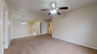Located at 131 McKinley Ct in Bull Creek, Missouri, this single-story home offers a practical and comfortable layout throughout. The living area is generously sized, featuring warm neutral-toned carpet and a ceiling fan with a light fixture, creating a welcoming atmosphere. A pendant chandelier adds a decorative touch, and the open sightlines connect seamlessly to adjacent spaces, enhancing the sense of flow. The kitchen is well-appointed with rich dark wood cabinetry, light-toned countertops, tile flooring, and a full suite of white appliances including a refrigerator, electric range, built-in microwave, and dishwasher. A window above the sink allows for natural light. Multiple carpeted bedrooms are present throughout the home, each featuring windows with blinds that invite natural light and ceiling fans for added comfort. The rooms are finished with clean white trim and neutral walls, providing a versatile backdrop. Two bathrooms serve the home: one includes a single-sink vanity with dark wood cabinetry and a tub/shower combination, while the second features a standalone walk-in shower, toilet, and overhead storage cabinet. Both bathrooms are finished with tile flooring and chrome fixtures, maintaining a consistent and clean aesthetic throughout the home.