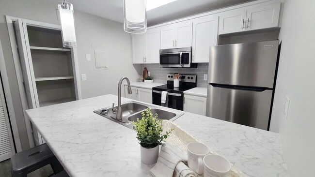 Kitchens that sparkle with marble-style countertops, wood-style flooring, and stainless-steel magic. - Carrington Lane