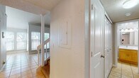 This two-story home offers a well-organized layout across two distinct levels, blending functional design with comfortable living spaces. The entry area features tile flooring, a staircase with white railings leading to the upper level, and a textured ceiling that continues throughout much of the home.

The main living area is bright and airy, boasting soaring ceilings and large windows that allow abundant natural light. A tile-surround fireplace serves as the room's focal point, adding warmth and character. The kitchen is equipped with stainless steel appliances, including a refrigerator, range, microwave, and dishwasher, complemented by warm wood-toned cabinetry and tile flooring. A security system keypad is conveniently located near the kitchen entrance.

Bedrooms are carpeted and well-lit, with ceiling fans providing comfort. The upper-level bedroom features vaulted ceilings with an exposed beam detail, enhancing the sense of space. One bedroom benefits from direct access to a bathroom and includes two closets alongside durable laminate wood flooring.

Bathrooms include tile flooring and are finished with warm wood vanities. One bathroom features a walk-in shower with grab bars, while another offers a full tub-shower combination.