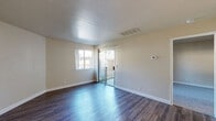Located at 7413 S Land Park Drive in Sacramento, CA, this single-floor, one-bedroom unit offers a well-organized layout across a compact but functional footprint. The living room serves as the heart of the space, featuring durable dark hardwood-style flooring, neutral beige walls, and a sliding glass door that opens to a private outdoor patio, filling the room with natural light and providing a seamless indoor-outdoor connection. A textured accent wall adds subtle visual interest to the living area.

The kitchen is efficiently designed with warm wood cabinetry extending to the ceiling for ample storage, white appliances including a refrigerator, range, and dishwasher, and light countertops with a single basin sink — all set over matching hardwood-style flooring that flows from the main living area.

The spacious bedroom offers plush carpeting for comfort, soft neutral tones, and a full-width mirrored sliding closet that enhances the sense of space while providing generous storage. A dedicated in-unit laundry area with a stacked washer and dryer is conveniently accessible from the bedroom hallway, adding a practical and sought-after amenity. Overall, the unit presents a clean, move-in ready aesthetic with functional details throughout.