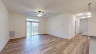 Located on Hadley Blvd in Enola, PA, this well-appointed single-floor, three-bedroom, two-bathroom home offers a thoughtfully designed layout with quality finishes throughout. The open-concept living area is a standout feature, showcasing warm wood-style plank flooring, crisp white walls, and a ceiling fan that anchors the space. Large sliding glass doors flood the room with natural light and provide direct access to an outdoor balcony, offering pleasant views of the surrounding greenery. The kitchen is positioned adjacent to the living area and features dark espresso cabinetry, granite countertops, pendant lighting, and stainless steel appliances, creating a functional and stylish cooking space. The primary bedroom is generously sized and carpeted for comfort, complete with a walk-in closet outfitted with wire shelving and hanging rods. Two additional bedrooms feature wood-style flooring and neutral tones, offering flexibility for various uses. Both bathrooms are finished with dark wood vanities, granite countertops, and light wood-style flooring. The main bathroom includes a full walk-in shower, while the second bathroom provides additional convenience. A hallway connects the living spaces seamlessly, and two closets provide ample storage throughout the home.
