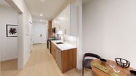 Located at 1701 Market St in Philadelphia's vibrant city center, this thoughtfully designed one-bedroom, one-bathroom residence offers a refined urban living experience across a single floor. The space is introduced by a welcoming entrance that flows into a sleek galley-style kitchen and living area. The kitchen features two-tone cabinetry — warm wood lower cabinets paired with white uppers — complemented by a marble-look quartz countertop, a gold-finish faucet, marble tile backsplash, and a full suite of stainless steel appliances. Light hardwood flooring runs throughout, enhancing the clean, modern aesthetic. The living room is anchored by large floor-to-ceiling windows that frame city views and flood the space with natural light. The bedroom continues the contemporary feel, offering its own expansive window overlooking the Philadelphia skyline, a ceiling fan, and ample closet storage. The spa-inspired bathroom is a standout, showcasing large-format white marble-look tile, a glass-enclosed walk-in shower with gold fixtures, and warm wood vanity cabinetry. Additional conveniences include an in-unit laundry area and multiple closets, ensuring practical storage throughout this polished urban residence.