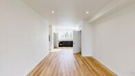 Located at 4383 N Vancouver Ave in Portland's vibrant North neighborhood, this modern three-story home offers five bedrooms and three bathrooms thoughtfully distributed across three equally sized floors. The interior showcases a clean, contemporary aesthetic defined by light hardwood flooring throughout, crisp white walls, and recessed lighting that creates a bright and welcoming atmosphere.

The main living area is open and airy, featuring sliding glass doors that lead to a private balcony with outdoor views, a wall-mounted mini-split system for climate control, and an abundance of natural light. The kitchen is well-appointed with dark navy cabinetry, light wood countertops, a double-basin stainless steel sink, and a dishwasher, centered around a large window framing neighborhood views.

The five bedrooms are generously proportioned, each with hardwood floors and natural light from well-placed windows. The primary bedroom offers a comfortable, spacious layout. Bathrooms are clean and functional, featuring both a walk-in shower and a soaking tub/shower combination. Carpeted staircases with warm wood handrails connect all three floors, adding a practical and polished touch. The home's efficient layout and modern finishes make it a versatile and comfortable residence.