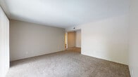 This single-floor, 2-bedroom, 2-bathroom residence offers a well-organized layout designed for comfortable everyday living. The spacious living area features neutral-toned carpet and warm beige walls, creating a clean, versatile backdrop for any furnishing style. Large sliding glass doors with vertical blinds allow natural light to pour in while providing outdoor access and views. A walk-in storage closet and utility closet add to the functional appeal of the living space.

The galley-style kitchen is efficiently designed with warm wood cabinetry, granite-patterned countertops, a stainless steel sink, and black appliances including a range, microwave, and refrigerator. A dedicated pantry closet provides additional storage. Wood-look flooring in the kitchen offers a durable, easy-to-maintain surface.

Both bedrooms are carpeted and generously sized. The primary bedroom includes a ceiling fan with light fixture and a window for natural light. One bedroom features a connected bathroom with wood vanity cabinetry, granite-style countertop, and a full tub/shower combo. The second full bathroom mirrors this configuration with a clean, white tiled tub/shower surround and wood-look flooring. The overall ambiance is neutral and move-in ready.