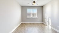 Located at 205 Rhyne Rd in Charlotte, NC, this single-floor unit offers a clean, contemporary design with a neutral color palette and consistent light wood-style flooring throughout. The open-concept layout connects the kitchen and living areas seamlessly, creating a functional and welcoming flow.

The kitchen is a standout feature, equipped with white shaker-style cabinetry, granite countertops, and a central island with an undermount sink. Stainless steel appliances—including a refrigerator, range, and microwave—complement the modern aesthetic. Recessed lighting brightens the space, and a paneled entry door and additional doors offer access to closet storage directly off the kitchen area.

The living and bedroom spaces are bright and airy, benefiting from natural light through horizontally slatted blinds. Bedrooms include ceiling fans and generous walk-in closets outfitted with wire shelving systems that provide organized, multi-level storage.

Bathrooms are finished with granite-topped white vanities, large frameless mirrors, pendant lighting, and combination tub/shower units with tiled surrounds. Each bathroom provides direct access to an adjacent walk-in closet, enhancing convenience. Clean white baseboards and neutral walls complete the polished, move-in-ready interior throughout.