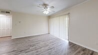 Located at 3415 W Hillsborough Ave in Tampa, FL, this one-bedroom, one-bathroom unit offers a well-organized single-floor layout designed for comfortable everyday living. The galley-style kitchen is a standout feature, equipped with stainless steel appliances including a range, microwave, and refrigerator, complemented by granite countertops, a stainless steel sink, and crisp white cabinetry. Rich hardwood-look flooring runs throughout the kitchen and main living areas, adding warmth and visual continuity. The open living room is bright and airy, featuring a ceiling fan with light fixture, crown molding, and a large sliding glass door with vertical blinds that invites natural light and provides outdoor views. The spacious primary bedroom is carpeted for comfort and features two windows that bring in additional natural light, a ceiling fan, and a mirrored sliding-door closet with built-in shelving. The full bathroom is finished with a granite-top vanity, white cabinetry with brushed nickel hardware, wood-look flooring, and a tub/shower combination. A connecting hallway ties the layout together efficiently, offering a functional flow between all rooms.