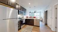 Located at 370 Carmelina Ave in Columbus, OH, this 2-bedroom, 1-bathroom residence offers a thoughtfully organized single-floor layout that makes excellent use of its compact footprint. Wood-style flooring runs throughout, providing a warm, cohesive aesthetic across all rooms.

The kitchen is a standout feature, equipped with stainless steel appliances — including a refrigerator, electric range, and microwave — complemented by rich dark cabinetry, white countertops, and a peninsula with pendant lighting that opens toward the living area. Natural light filters through large windows in the living room, which offers comfortable space for seating and relaxation.

The primary bedroom is a well-proportioned retreat with natural light from a large window, while the second bedroom provides additional flexibility for guests or a home office. Both rooms feature wood-style flooring and clean, neutral wall tones. A dedicated closet area offers generous hanging storage.

The bathroom is finished with a white vanity, wood-style flooring, and a glass-enclosed shower/tub combination, maintaining the clean and modern aesthetic found throughout the home. A welcoming entryway with crisp white paneled doors completes the layout. This residence delivers a functional, modern living experience in a convenient Columbus location.