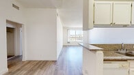 Located at 11657 Oxnard St in North Hollywood, CA, this one-bedroom, one-bathroom unit offers a functional and well-organized single-floor layout. The open-concept living and kitchen area forms the heart of the space, where light wood-style flooring flows seamlessly throughout. A large window in the living room invites an abundance of natural light, creating a bright and airy atmosphere.

The kitchen is designed for efficiency, featuring white cabinetry, granite-style countertops, a double-basin sink, a gas range, and a full-size refrigerator. A peninsula counter serves as a natural divider between the kitchen and living area, providing additional prep space and a casual serving surface. A mosaic tile backsplash adds a subtle decorative touch near the range.

The bedroom is a comfortable, well-proportioned retreat bathed in natural light from a generously sized window. It includes a mirrored sliding-door closet, offering practical storage. The bathroom is outfitted with a tiled tub-and-shower combination featuring a handheld showerhead, a toilet, and a granite-style vanity countertop with wood-style flooring. Textured ceilings are present throughout the unit, and a hallway connects the main living spaces efficiently.