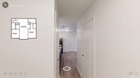 This well-appointed 2-bedroom, 2-bathroom residence in Durham, NC offers a thoughtfully designed single-floor layout. The open kitchen and living area serves as the heart of the home, featuring a modern kitchen with two-tone cabinetry — white upper cabinets paired with slate-blue lower cabinets — complemented by light countertops, a stainless steel sink, and a full suite of stainless steel appliances including a refrigerator, range, microwave, and dishwasher. Track lighting overhead adds a contemporary touch, while light wood-look flooring flows throughout the main living areas.

Both bedrooms are generously sized, with plush carpeting, ceiling fans with integrated lighting, and windows that bring in natural light and views of surrounding greenery. Each bedroom is served by its own walk-in closet, fitted with wire shelving systems for organized storage. The bathrooms feature a clean, neutral palette with light wood flooring, a tub/shower combo, and dark-toned vanity cabinetry.

A connecting hallway links all areas of the home efficiently. The primary bedroom is particularly spacious, offering ample room and direct closet access. The overall ambiance is bright, clean, and move-in ready, with a cohesive neutral color scheme throughout.