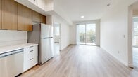 Located at 900 N Ardmore Ave in Los Angeles, CA, this modern 2-bedroom, 2-bathroom unit offers a thoughtfully designed single-level layout with a clean, contemporary aesthetic throughout. Light wood-tone flooring flows seamlessly across every room, complementing the crisp white walls and recessed lighting that give the space a bright, airy feel.

The open-concept living and dining area is anchored by a sliding glass door that leads to a private balcony, filling the room with natural light and offering views of the surrounding Los Angeles landscape. The adjacent kitchen is well-appointed with warm wood upper cabinetry, white lower cabinets, white quartz countertops, a tile backsplash, and stainless steel appliances including a range, dishwasher, and refrigerator — all finished with sleek matte black hardware.

Both bedrooms are generously proportioned, with large windows that bring in ample natural light and views of the tree-lined neighborhood. The primary bedroom includes a sliding-door closet for efficient storage. A second closet is also available within the unit.

The two bathrooms are clean and modern, each featuring a soaking tub with shower, white tile surround, and light wood flooring. A dedicated laundry area and two hallways round out this well-organized and functional floor plan.