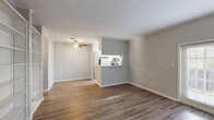 This well-appointed 2-bedroom, 1-bathroom residence in Lafayette, Louisiana offers a thoughtfully designed single-floor layout that maximizes functionality and comfort. The open-concept living area is anchored by durable wood-look flooring and neutral gray tones throughout, creating a clean, cohesive aesthetic. A standout feature is the set of French doors in the living room, which flood the space with natural light and provide access to the outdoors. A ceiling fan adds both style and practicality to the main living area.

The kitchen is designed with efficiency in mind, featuring a peninsula with a light-toned countertop that opens to the living space, white cabinetry with ample storage, stainless steel appliances including a refrigerator and range, and a window above the sink for added natural light. A prominent built-in shelving unit in the living area offers generous display and storage options.

The two bedrooms are finished with wood-look flooring and ceiling fans, with windows framing views of surrounding greenery. The primary bedroom includes a dedicated walk-in closet with dual hanging rods and shelving. The bathroom features a tiled tub-shower combination. A textured ceiling is present throughout the home, adding a classic finishing touch.