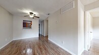 Located at 400 W Saint Elmo Rd in Austin, TX, this single-floor, 2-bedroom, 2-bathroom home offers a practical and comfortable layout. Wood-look flooring runs throughout, complemented by neutral-toned walls and textured ceilings that lend a consistent, clean aesthetic across the space.

The open living and dining area is bright and airy, with a ceiling fan overhead and a front entry door flanked by a window that lets in natural light. A pass-through window connects the living area to the kitchen, which features warm wood cabinetry and a full-size refrigerator. An adjacent utility and laundry room adds everyday convenience.

The primary bedroom is a comfortable size, highlighted by a ceiling fan and a sliding glass door that opens to an outdoor view of mature trees, providing both natural light and a pleasant connection to the outdoors. The second bedroom is well-proportioned with ample natural light. Both bedrooms feature closet storage, including a double-door closet option.

The bathrooms are thoughtfully appointed, with one featuring rich wood cabinetry, a granite countertop with a vessel sink, a framed mirror, overhead storage, and a full tub-shower combination. Wood-look flooring carries through the bathrooms, maintaining a cohesive design throughout the home.