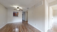 Located at 400 W Saint Elmo Rd in Austin, TX, this single-floor, 2-bedroom, 2-bathroom home offers a practical and comfortable layout. Wood-look flooring runs throughout, complemented by neutral-toned walls and textured ceilings that lend a consistent, clean aesthetic across the space.

The open living and dining area is bright and airy, with a ceiling fan overhead and a front entry door flanked by a window that lets in natural light. A pass-through window connects the living area to the kitchen, which features warm wood cabinetry and a full-size refrigerator. An adjacent utility and laundry room adds everyday convenience.

The primary bedroom is a comfortable size, highlighted by a ceiling fan and a sliding glass door that opens to an outdoor view of mature trees, providing both natural light and a pleasant connection to the outdoors. The second bedroom is well-proportioned with ample natural light. Both bedrooms feature closet storage, including a double-door closet option.

The bathrooms are thoughtfully appointed, with one featuring rich wood cabinetry, a granite countertop with a vessel sink, a framed mirror, overhead storage, and a full tub-shower combination. Wood-look flooring carries through the bathrooms, maintaining a cohesive design throughout the home.
