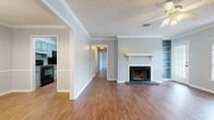 Located at 3800 Morrison Dr in Monroe, Louisiana, this single-story, 2-bedroom, 2-bathroom home offers a well-organized layout across a comfortable and functional floor plan. The living room serves as the heart of the home, featuring warm wood-look flooring, crown molding, a textured ceiling with a ceiling fan, and a classic fireplace with a white mantel and slate surround. Built-in shelving flanks the fireplace, providing both storage and display space. A charming arched window allows natural light to fill the room. The adjacent dining area features chair-rail molding and flows directly into the galley-style kitchen, which is equipped with blue-gray cabinetry, granite-look countertops, a stainless steel refrigerator, dishwasher, and range. The primary bedroom is generously sized, offering ample room and continued wood-look flooring. Both bedrooms are bright with neutral light-gray walls and clean white trim. The two bathrooms are finished with gray vanity cabinetry and full tub-shower combinations. Additional amenities include a dedicated laundry area, a hallway connecting the private spaces, and a closet for extra storage. Crown molding and consistent flooring throughout tie the home together with a cohesive, polished look.